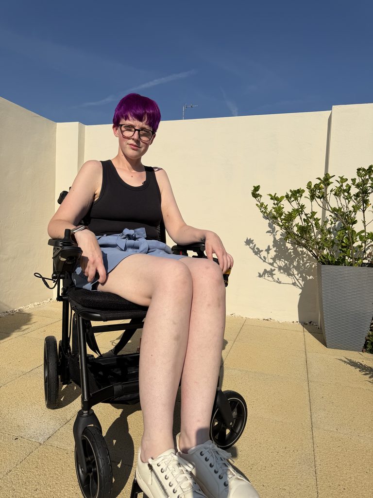 Leah in her Navigator powerchair in the sunshine.